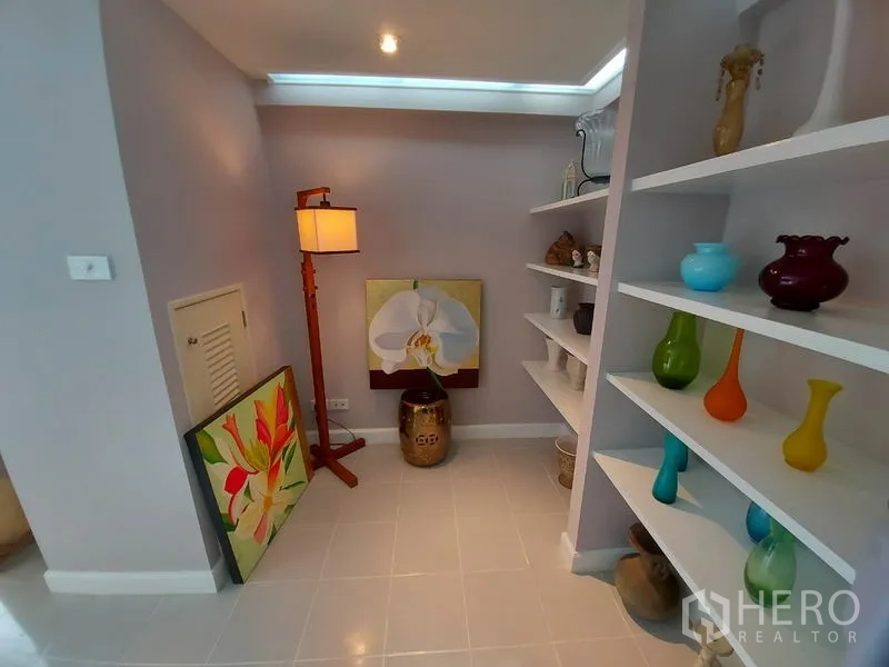 公寓 出租或出售在Watthana, Bangkok - 温馨小角落，展示架、彩色花瓶、落地灯与装饰画。