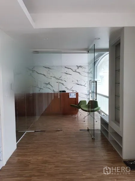 零售空间 出租在Khlong Toei, Bangkok - 玻璃隔断的接待区，大理石纹墙、木地板与绿色椅子，采光充足。