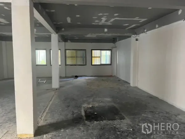 零售空间 出租在Pathum Wan, Bangkok - 开放式零售楼层，多扇窗户、白墙与灰色梁。