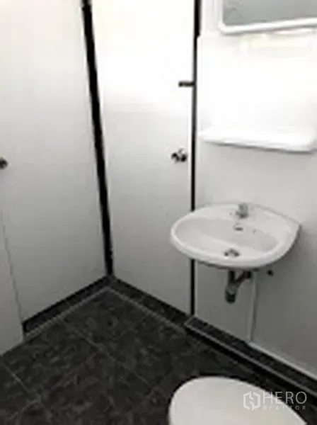 Detached House for rent in Suan Luang, Bangkok - Simple white bathroom with pedestal sink, mirror, and tiled floor.