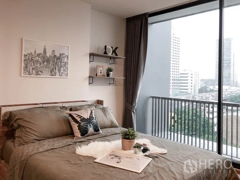 คอนโด ให้เช่าหรือขายในBang Rak, Bangkok - ห้องนอนสว่างไสว มีหน้าต่างบานใหญ่ ราวระเบียง ชั้นวางของ และวิวเมือง