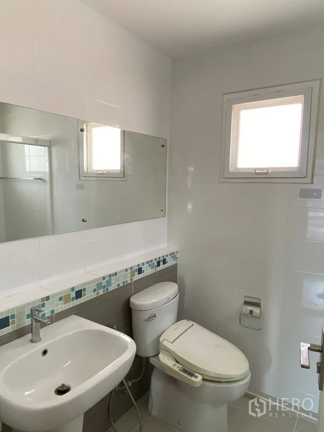 Detached House for rent in Prawet, Bangkok - Compact bathroom with sink, large mirror, and a window.