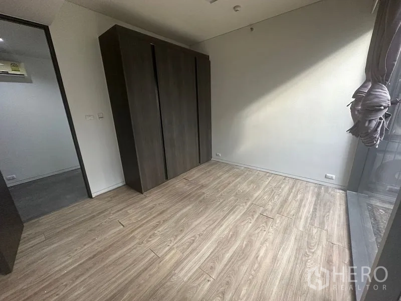 สำนักงาน ให้เช่า - ห้องทำงานส่วนตัวพร้อมตู้เสื้อผ้าบิวท์อินสีเข้ม พื้นไม้ และหน้าต่างรับแสงจากคอร์ต