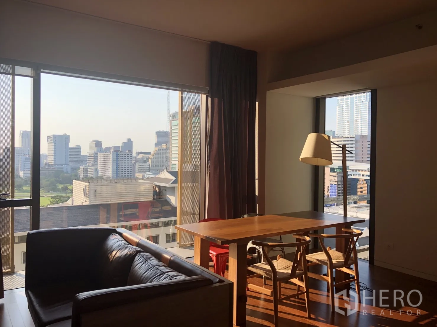 公寓 出租在Pathum Wan, Bangkok - 餐区临大幅观景窗，远眺曼谷天际线与皇家曼谷运动俱乐部绿意