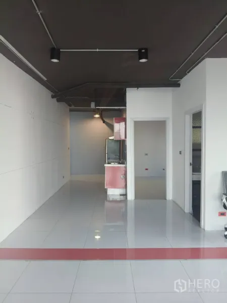 สำนักงาน ให้เช่าในKhlong Toei, Bangkok - ออฟฟิศแบบโอเพนสเปซ พื้นกระเบื้องสีขาว เพดานสีดำเปลือย และครัวขนาดกะทัดรัดด้านหลัง