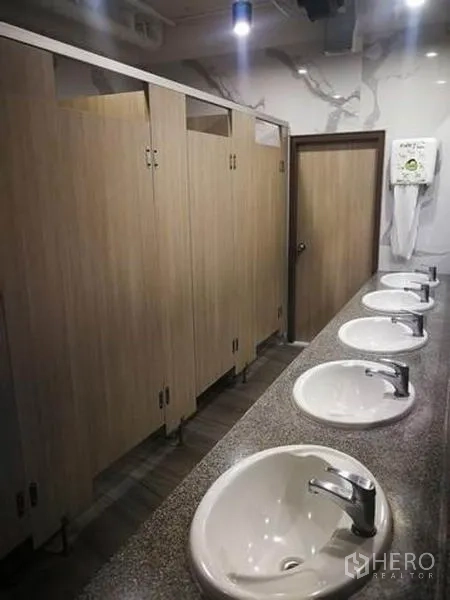 零售空间 出租在Phaya Thai, Bangkok - 公共卫生间区域，多个洗手盆与木纹隔间门