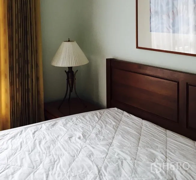 คอนโด ให้เช่าในWatthana, Bangkok - มุมห้องนอนพร้อมเตียงหัวไม้ โคมไฟข้างเตียง ผ้าม่านยาว และกรอบรูป