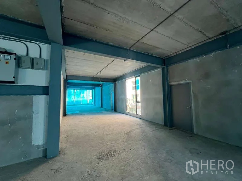 零售空间 出租在Pathum Wan, Bangkok - 零售区展示配电箱、混凝土墙、大幅展示窗与侧门。