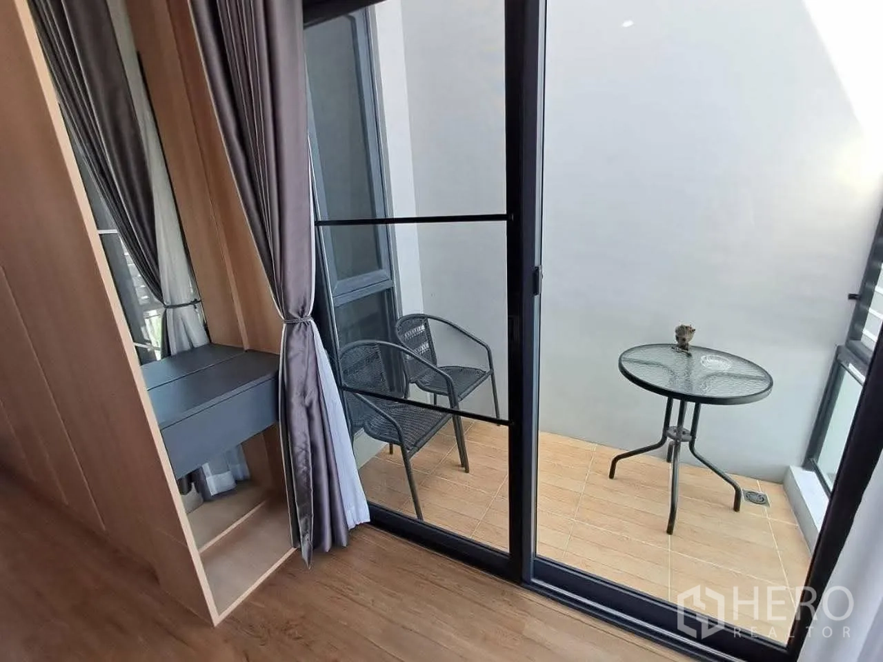 联排别墅 for rent in Bang Kapi, Bangkok - 小阳台上有圆形玻璃桌与两把椅子，外侧为推拉门。