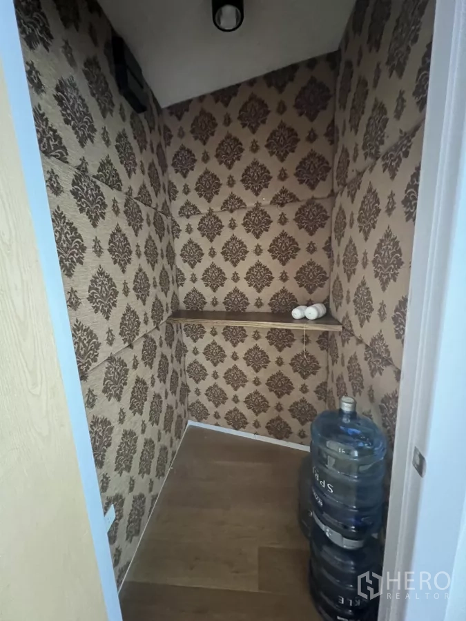 零售空间 出租在Khlong Toei, Bangkok - 小型储物间，墙纸装饰，带搁板和桶装水。