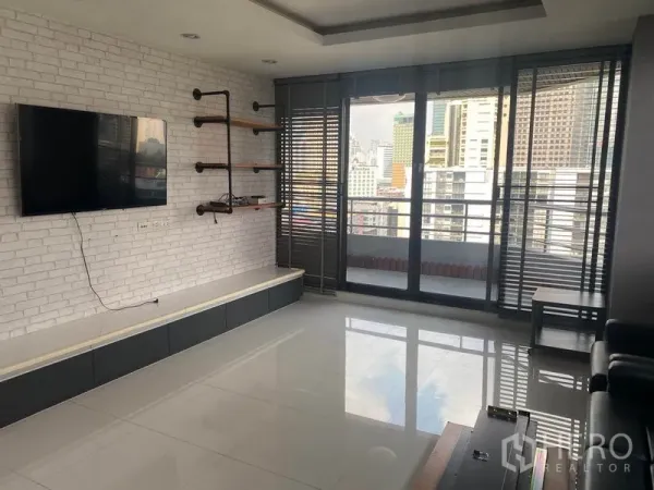 คอนโด ให้เช่าในKhlong Toei, Bangkok - ห้องนั่งเล่นเชื่อมต่อระเบียง ผนังอิฐขาว ทีวีติดผนัง และวิวสกายไลน์