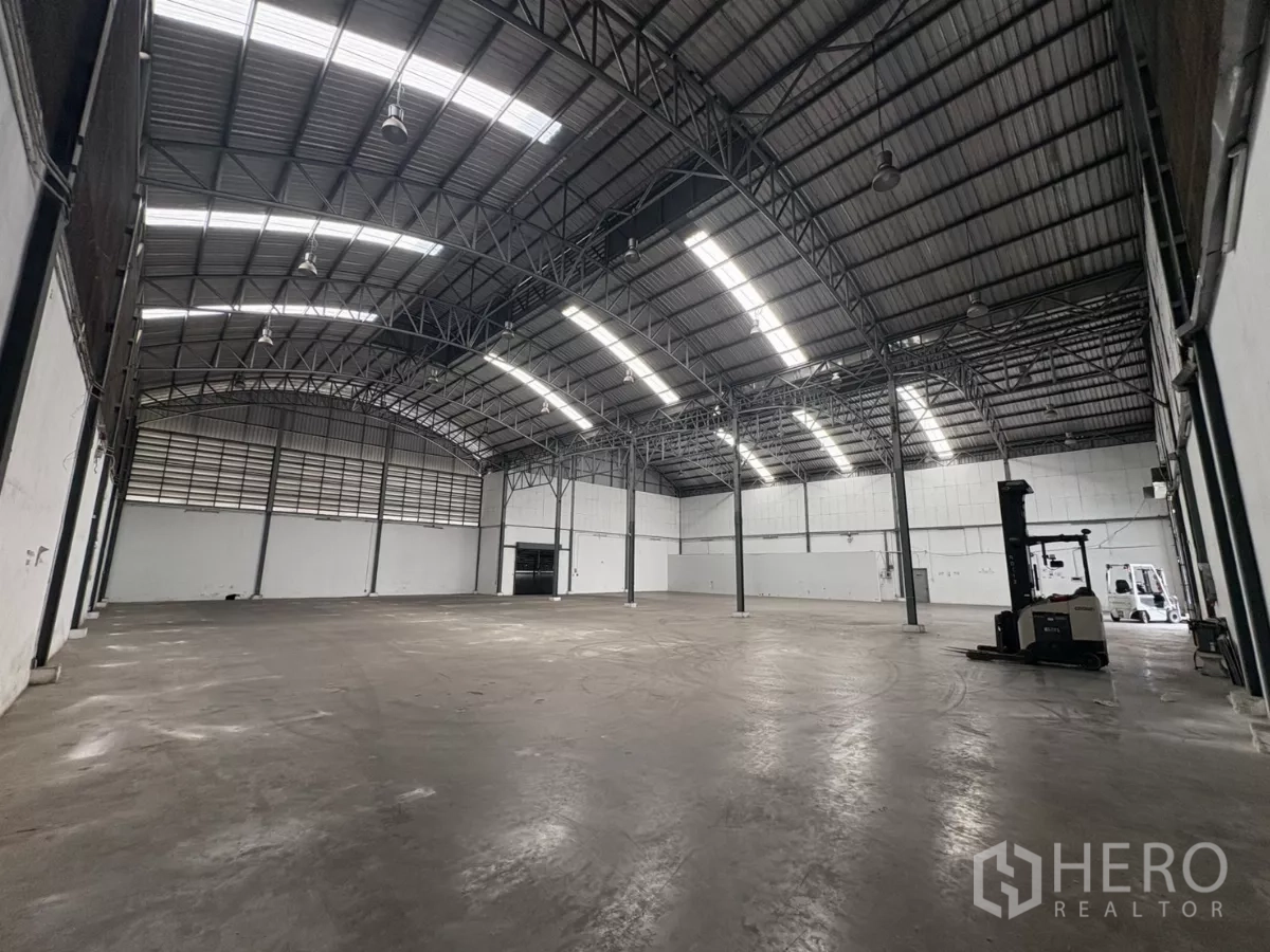 คลังสินค้า ให้เช่าในBang Phli, Samut Prakan - ช่วงโกดังลึก หลังคาสูงพร้อมช่องระบายอากาศและไฟแถบสว่าง.