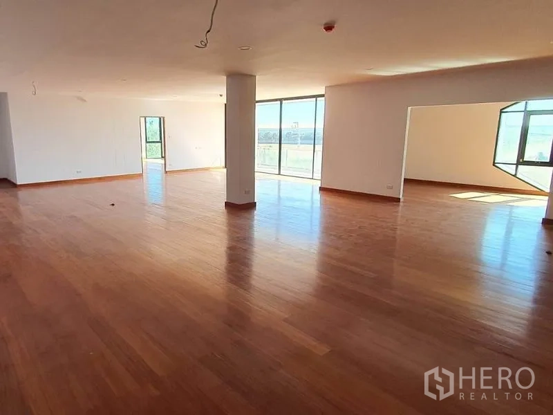 Warehouse for rent in Samut Prakan - Large office or showroom space with polished wooden flooring and natural light.