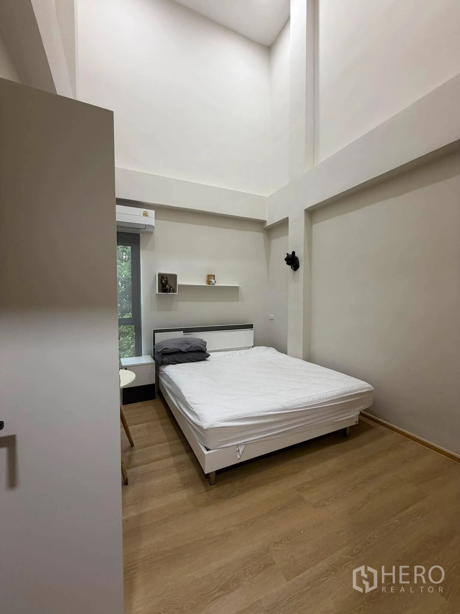โฮมออฟฟิศ for rent in Phra Khanong, Bangkok - ห้องนอนอีกห้องเพดานสูงพร้อมเตียงและโต๊ะข้าง