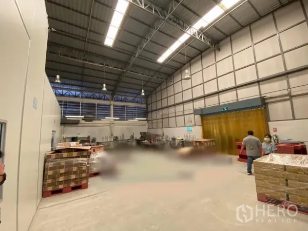 คลังสินค้า ให้เช่าในBueng Kum, Bangkok - ภายในโกดังเพดานสูง โครงหลังคาเหล็ก ช่องลมบานเกล็ด พาเลท และม่านริ้ว PVC สีเหลือง
