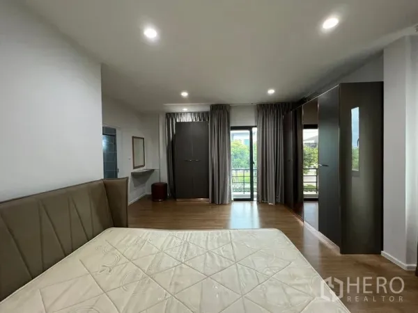 บ้าน ให้เช่าในSaphan Sung, Bangkok - ห้องนอนมาสเตอร์กว้าง พื้นไม้ เตียงใหญ่ ตู้เสื้อผ้า และประตูกระจกออกระเบียงพร้อมผ้าม่าน