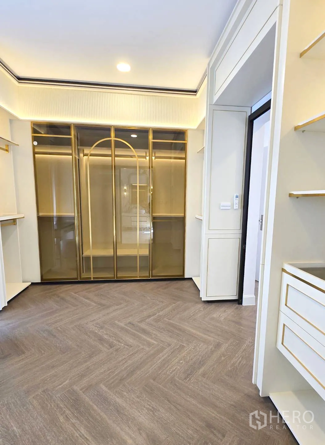 Detached House for rent in Saphan Sung, Bangkok - Another view of the walk‑in closet with glass wardrobes and herringbone floor.