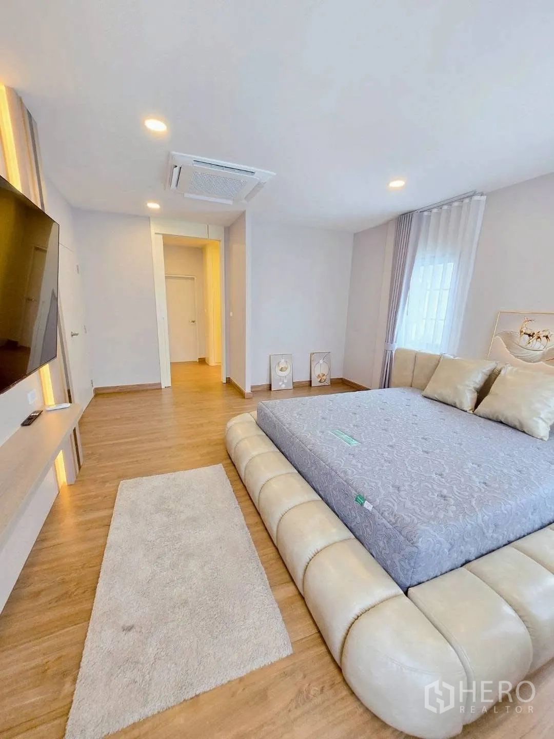 Detached House for rent in Bang Phli, Samut Prakan - Master bedroom view toward the TV console with a soft rug beside the bed.
