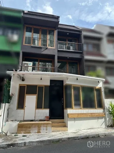 带办公室的家 出租在Watthana, Bangkok - 通罗瓦他那三层联排式住办两用外观，木框窗与阳台。