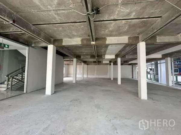 Retail Space for rent in Khlong Toei, Bangkok - Open-plan retail floor with exposed concrete ceiling, white columns and large windows.