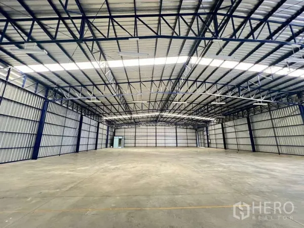 Warehouse for rent in Lat Krabang, Bangkok - Spacious warehouse interior with high steel trusses, skylight panels and smooth concrete floor.
