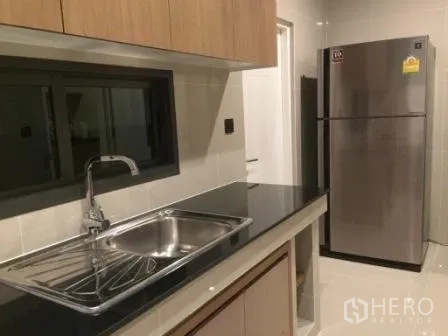 Detached House for rent in Bang Kapi, Bangkok - Secondary kitchenette with stainless sink, window and double-door refrigerator.