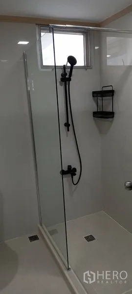 公寓 出租在Watthana, Bangkok - 现代浴室，玻璃淋浴间与黑色花洒。