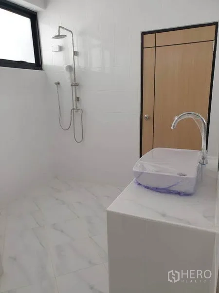 带办公室的家 出租或出售在Bang Na, Bangkok - 白色瓷砖浴室，淋浴与玻璃面盆。