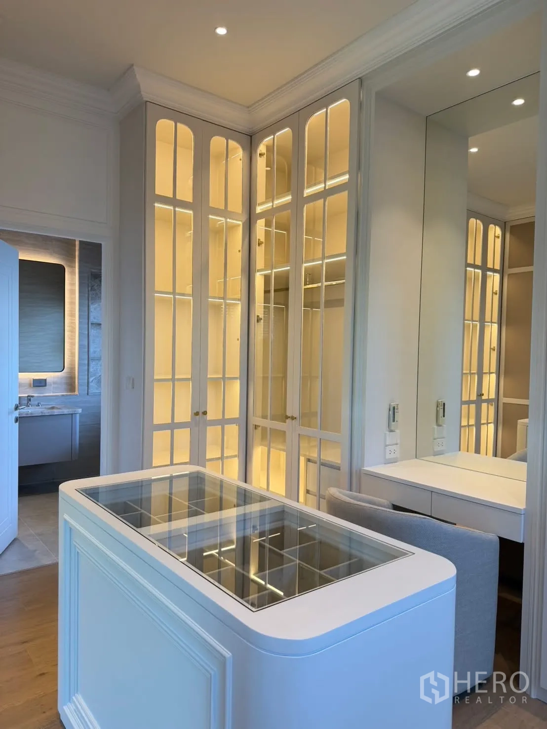 Detached House for rent in Saphan Sung, Bangkok - Dressing room with glass-topped storage island, lighted display cabinets, and vanity.