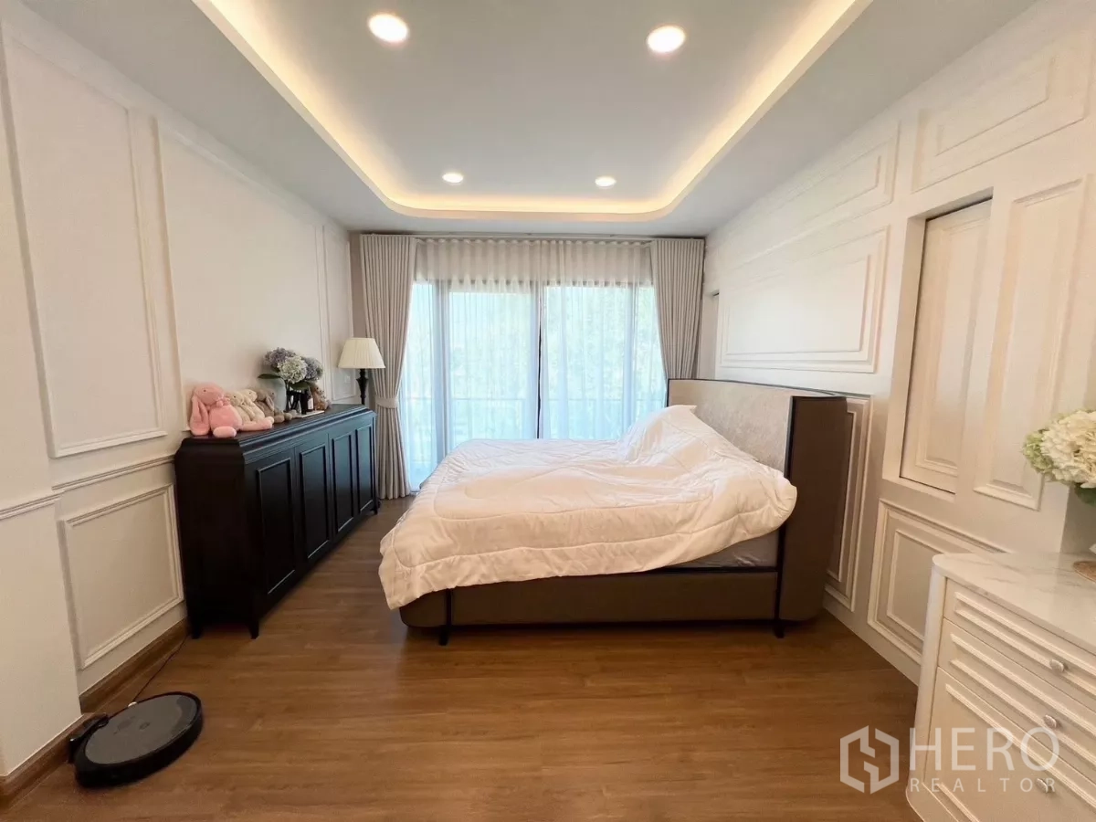 Detached House for rent in Bang Phli, Samut Prakan - Master bedroom with balcony access, wall mouldings and wood flooring.
