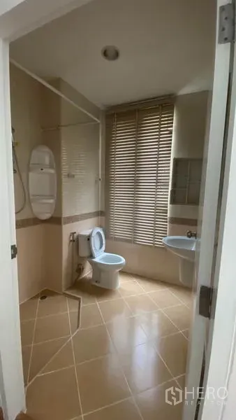 Townhouse for rent in Wang Thonglang, Bangkok - Bathroom with shower area, toilet, sink, and window blinds.
