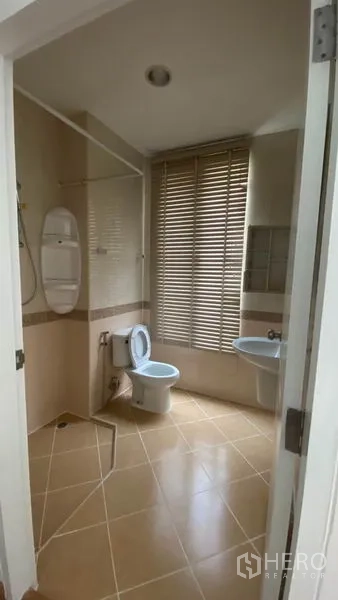 Townhouse for rent in Wang Thonglang, Bangkok - Bathroom with shower area, toilet, sink, and window blinds.