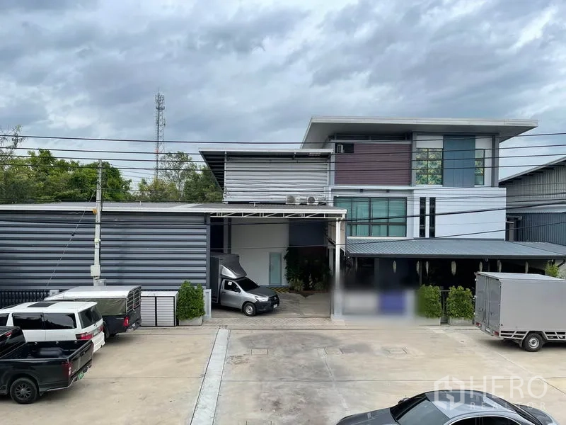 工厂 出租或出售在Pathum Thani - 现代化厂房与办公楼外观，带装卸雨棚和停车位。