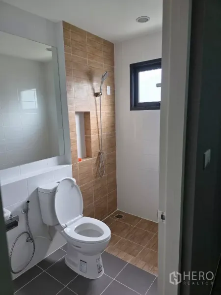 Detached House for rent in Bang Phli, Samut Prakan - Bathroom with walk-in shower, brown accent tiles, window and white sanitary ware.