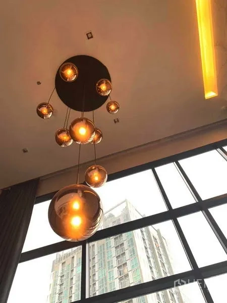 Condominium for rent or sale in Huai Khwang, Bangkok - Cluster of modern pendant lights hanging from a high ceiling near tall windows.