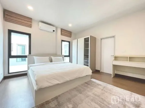 Detached House for rent in Bang Phli, Samut Prakan - Spacious bedroom with double bed, air conditioner, wardrobes, desk and two windows.