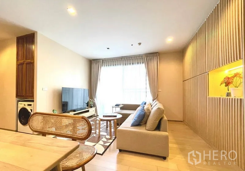 คอนโด ให้เช่าหรือขายในWatthana, Bangkok - อีกมุมของห้องนั่งเล่น พร้อมทีวี โซฟา ระเบียง และตู้ซักผ้าในช่องบิวท์อิน