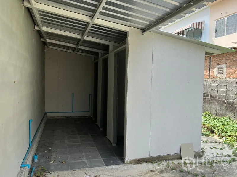 Warehouse for rent in Min Buri, Bangkok - External utility block with covered walkway and restroom stalls beside the warehouse.