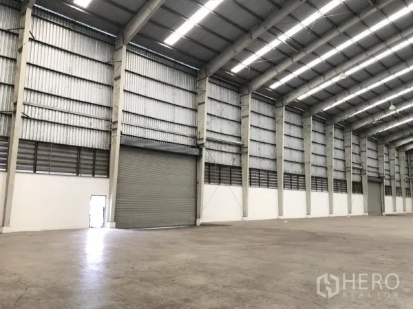 货栈 出租在Phra Nakhon Si Ayutthaya - 室内大型卷闸门、通风百叶与重载混凝土地面。