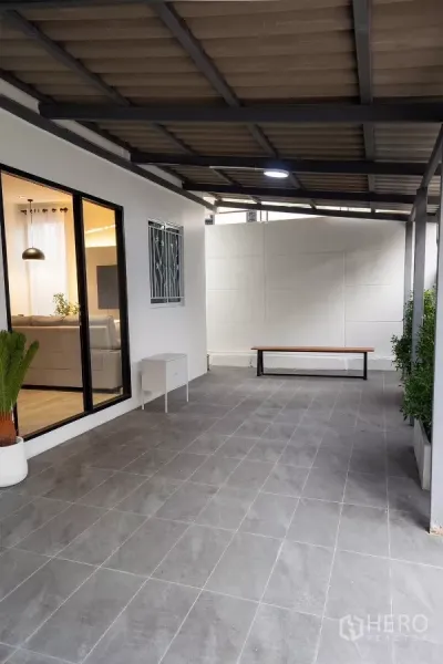 บ้าน ให้เช่าในHuai Khwang, Bangkok - พื้นที่เฉลียงและโรงจอดรถมุงหลังคาปูกระเบื้องสีเทา ข้างประตูบานเลื่อน