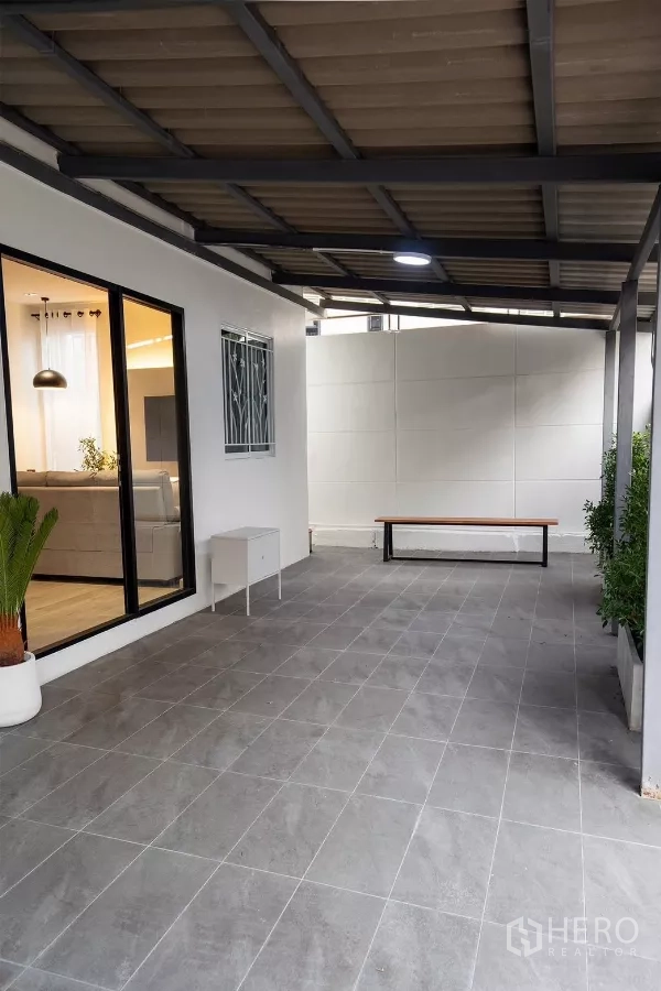 บ้าน ให้เช่าในHuai Khwang, Bangkok - พื้นที่เฉลียงและโรงจอดรถมุงหลังคาปูกระเบื้องสีเทา ข้างประตูบานเลื่อน