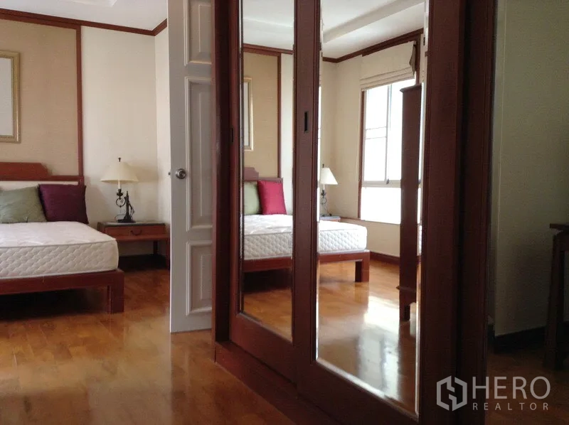 คอนโด ให้เช่าหรือขายในWatthana, Bangkok - ห้องนอนหลักมีตู้เสื้อผ้าบานกระจก โต๊ะข้างเตียง และพื้นไม้