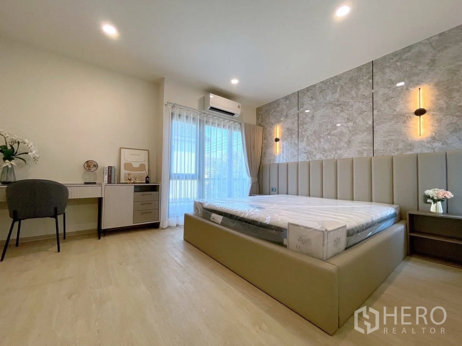 Detached House for rent in Bang Phli, Samut Prakan - Master suite with large bed, study desk and floor-to-ceiling window opening to balcony.