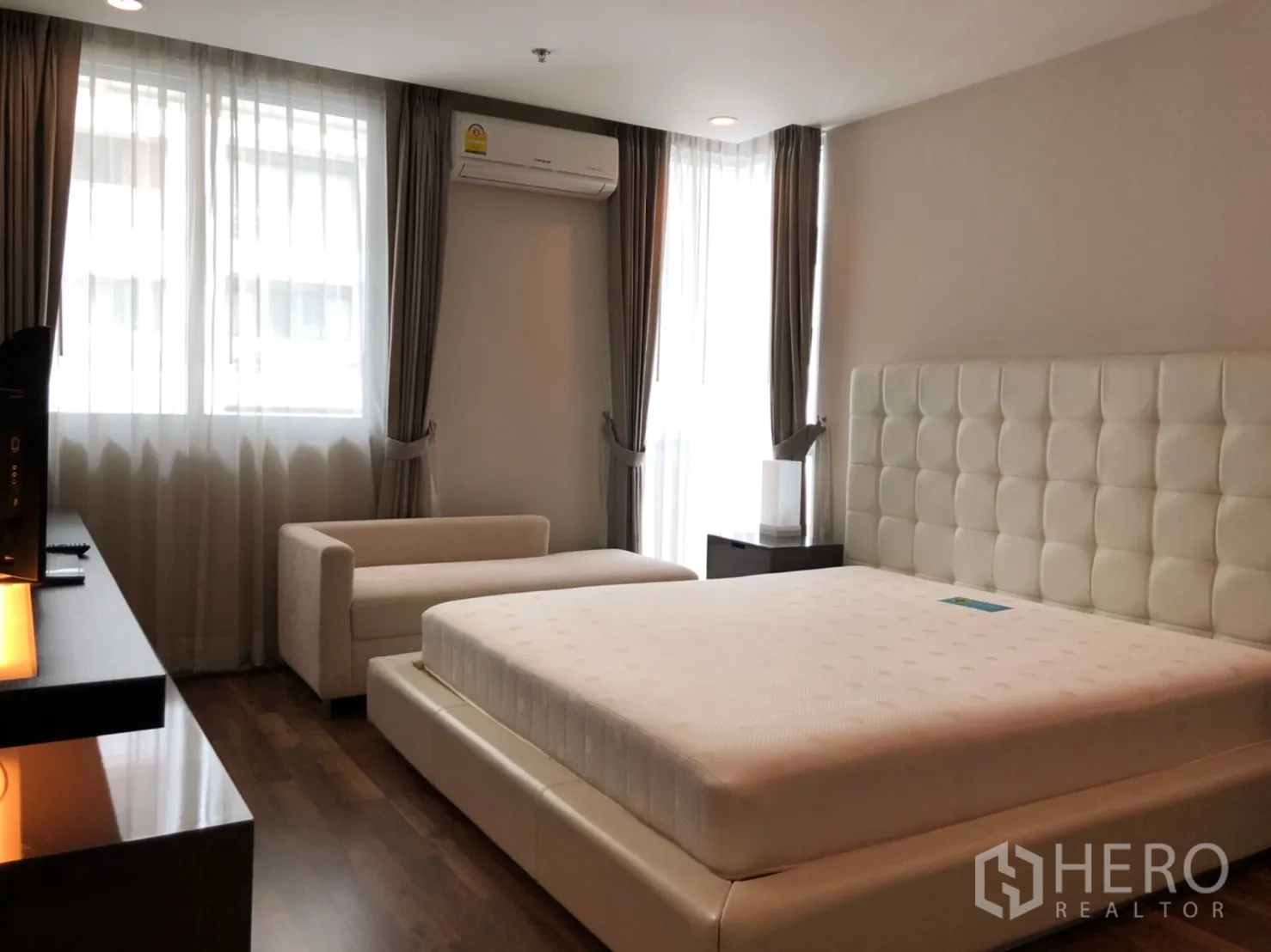 คอนโด ให้เช่าในPathum Wan, Bangkok - มาสเตอร์เบดรูมกว้าง หัวเตียงบุนุ่ม เตียงคิง โซฟายาว พื้นไม้ และหน้าต่างบานใหญ่