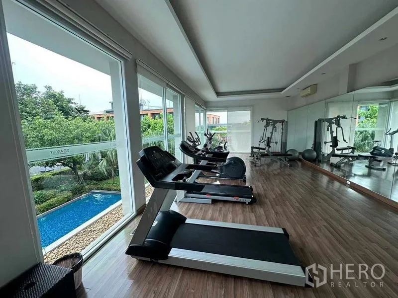 Detached House for sale in Saphan Sung, Bangkok - Fitness room with treadmills, bikes and weight machines overlooking the pool.