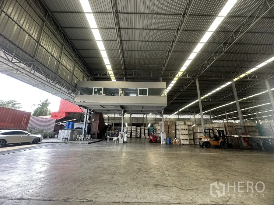 工厂 出租 - 开放式厂房带夹层办公室，叉车作业与货物堆垛，照明明亮。