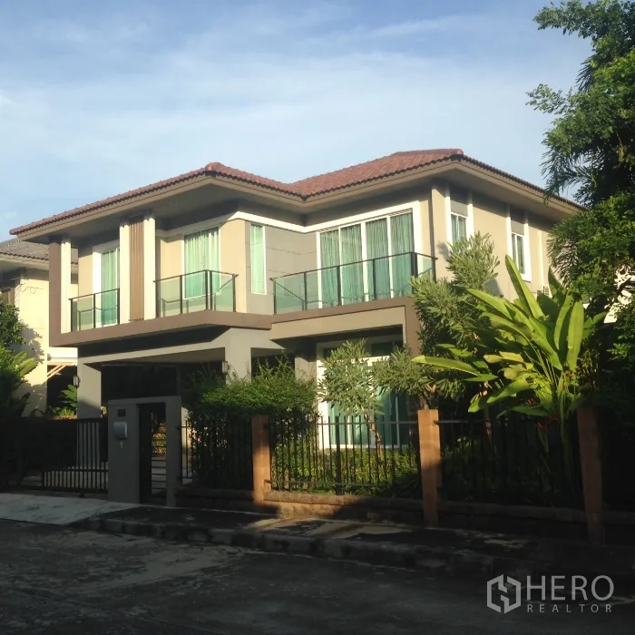 Detached House for rent in Pathum Thani - Two-storey detached house with modern facade, balconies and a gated front garden.
