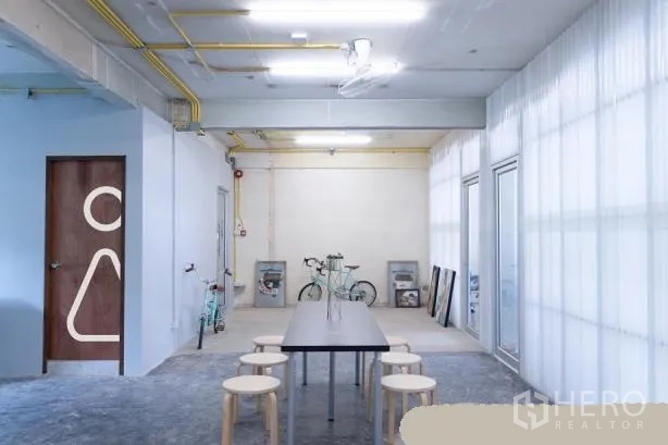สำนักงาน ให้เช่าในPhaya Thai, Bangkok - โซนส่วนกลางสไตล์มินิมอลอุตสาหกรรม โต๊ะยาว ม้านั่ง เพดานเดินท่อ และผนังกั้นโปร่งแสง