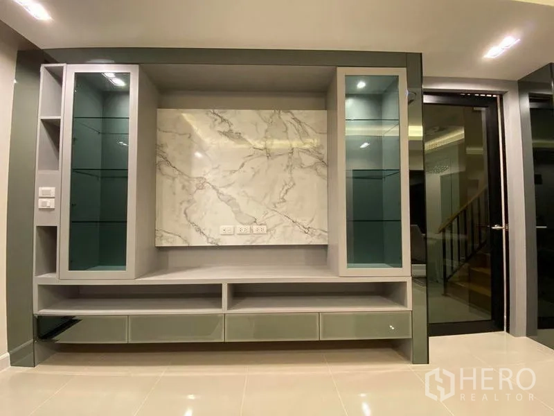Detached House for rent - Custom TV feature wall with marble panel and glass display cabinets.