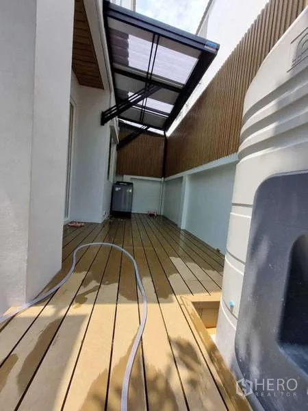 ทาวน์เฮาส์ ให้เช่าในWang Thonglang, Bangkok - ระเบียงข้างบ้านปูพื้นไม้เทียม มุงกันสาด และถังเก็บน้ำ